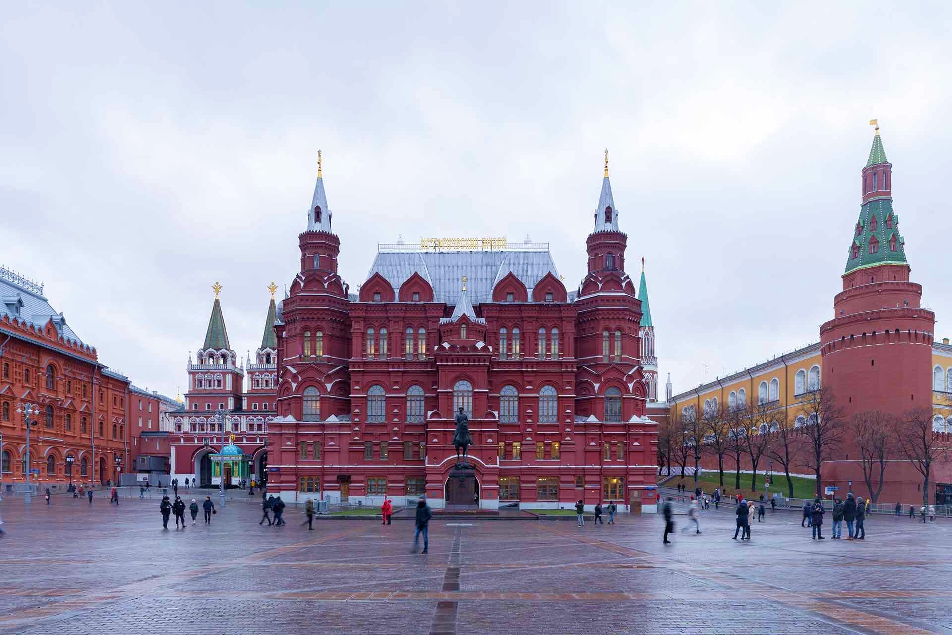 Russia Visa Red brick historic buildings and towers surrounding a large public square in Moscow's Red Square with pedestrians walking